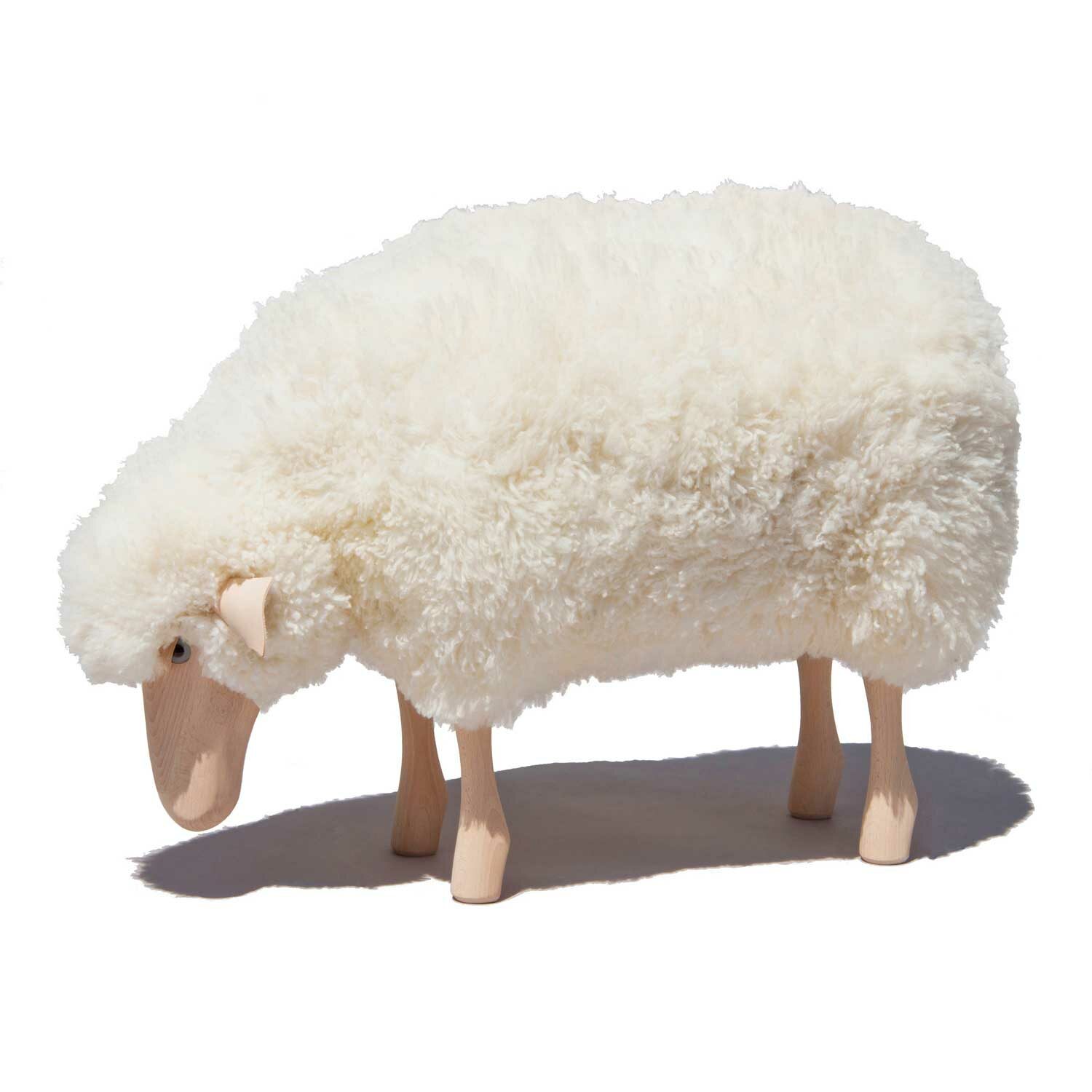 Kleines Schaf grasend mit weißem Schaffell